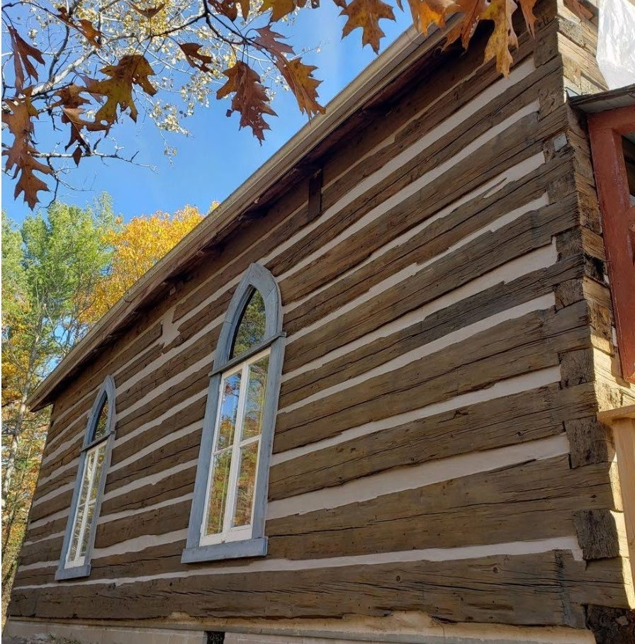Log home contractor performing detailed sanding work near Bancroft